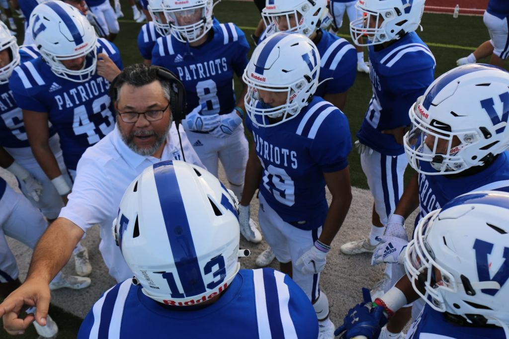Football coach in a huddle with players