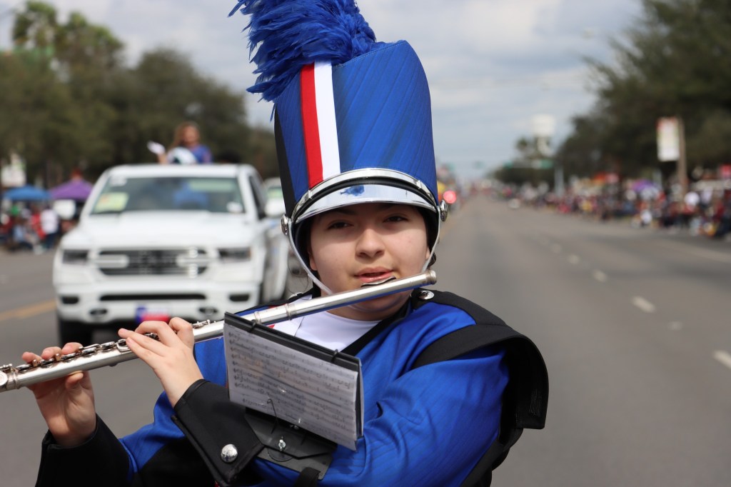 high school flute player while marching in a parade.